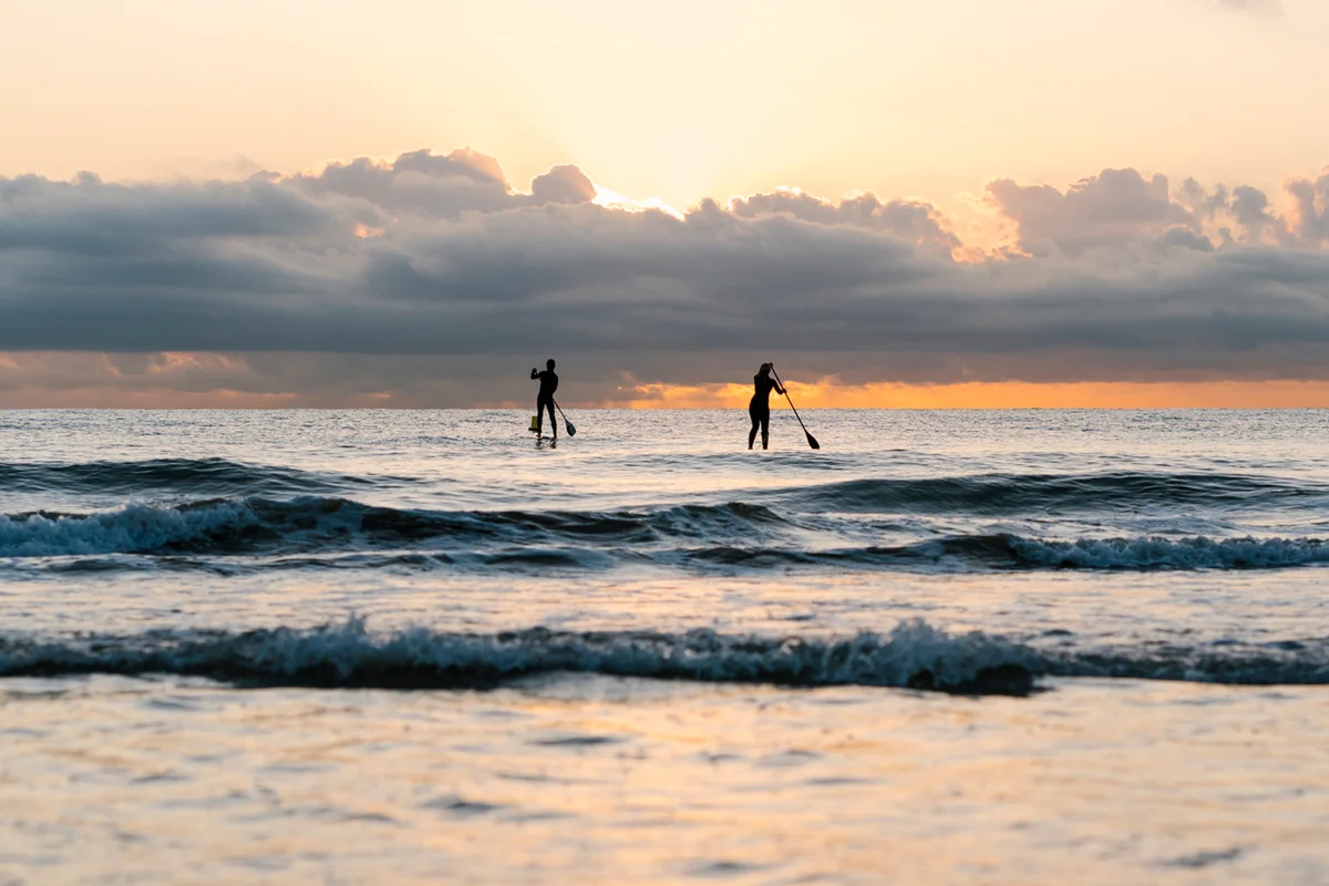 paddleboarding on Mediterranean Sea against sky at dawn