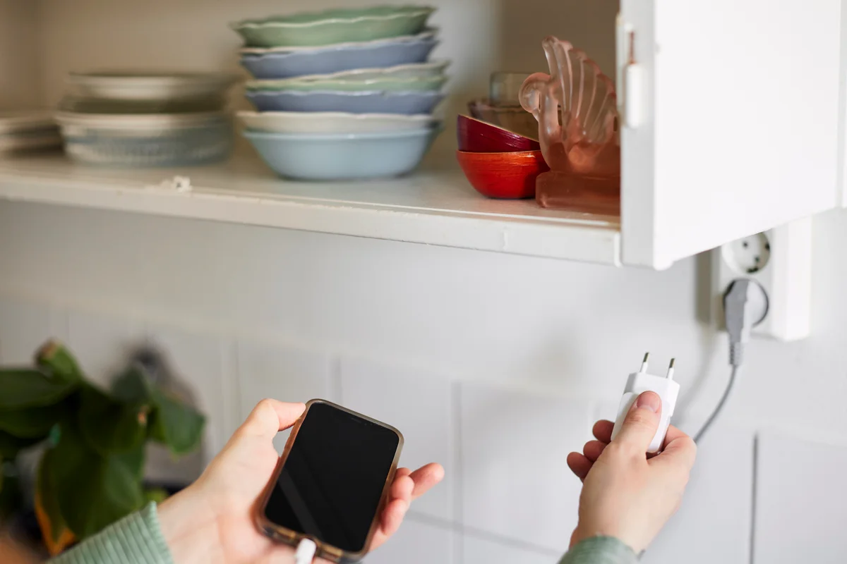 person charging phone on kitchen