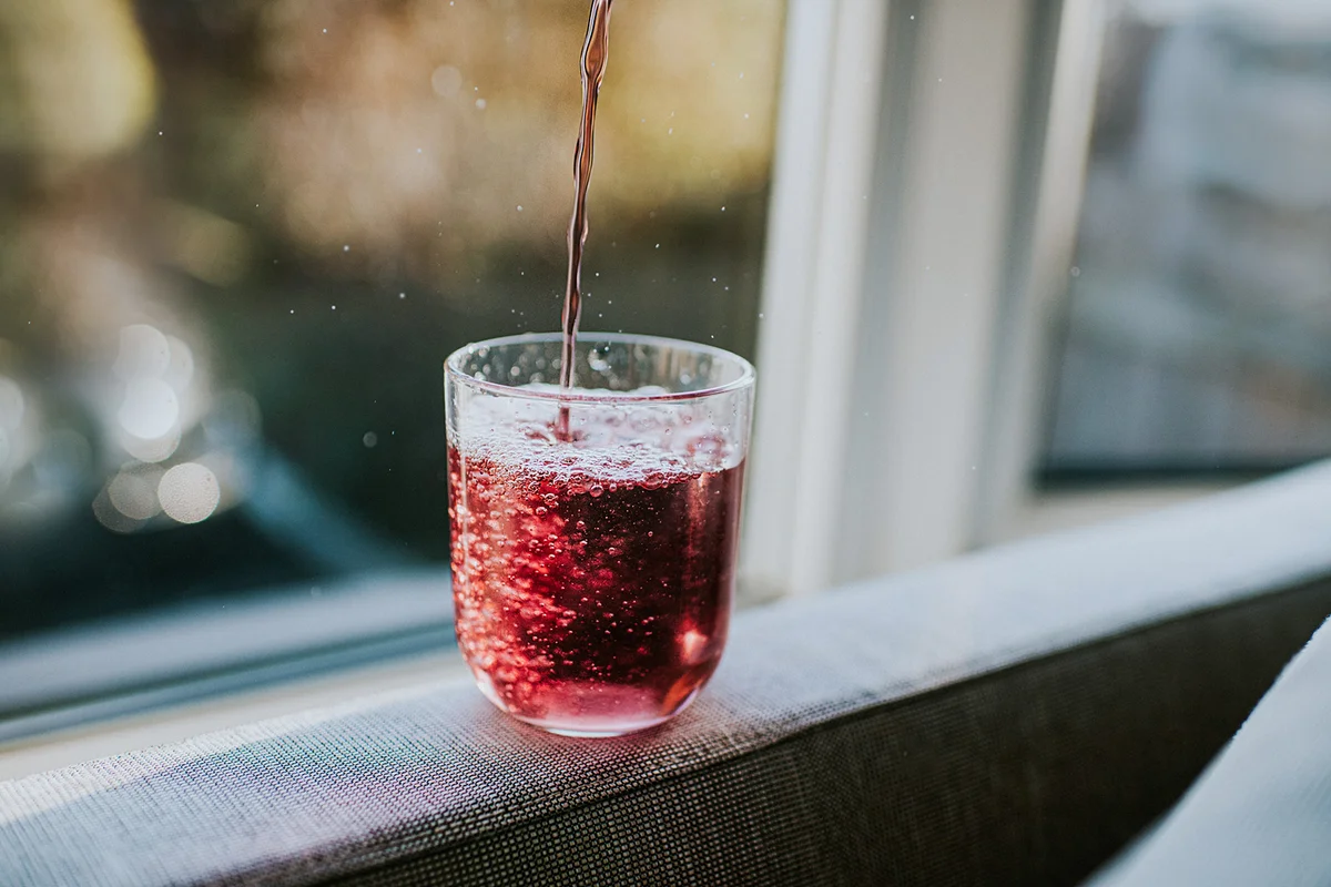 Adding concentrated juice to a glass of water