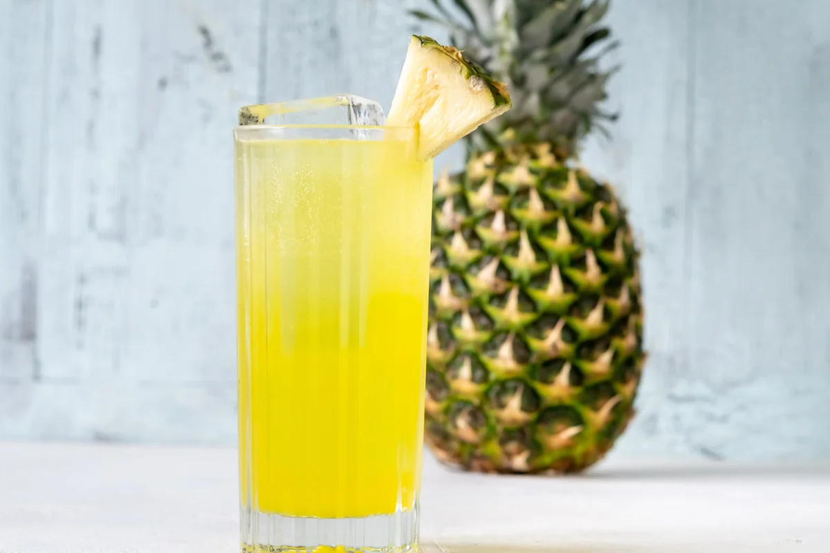 Pisco Punch cocktail garnished with pineapple wedge