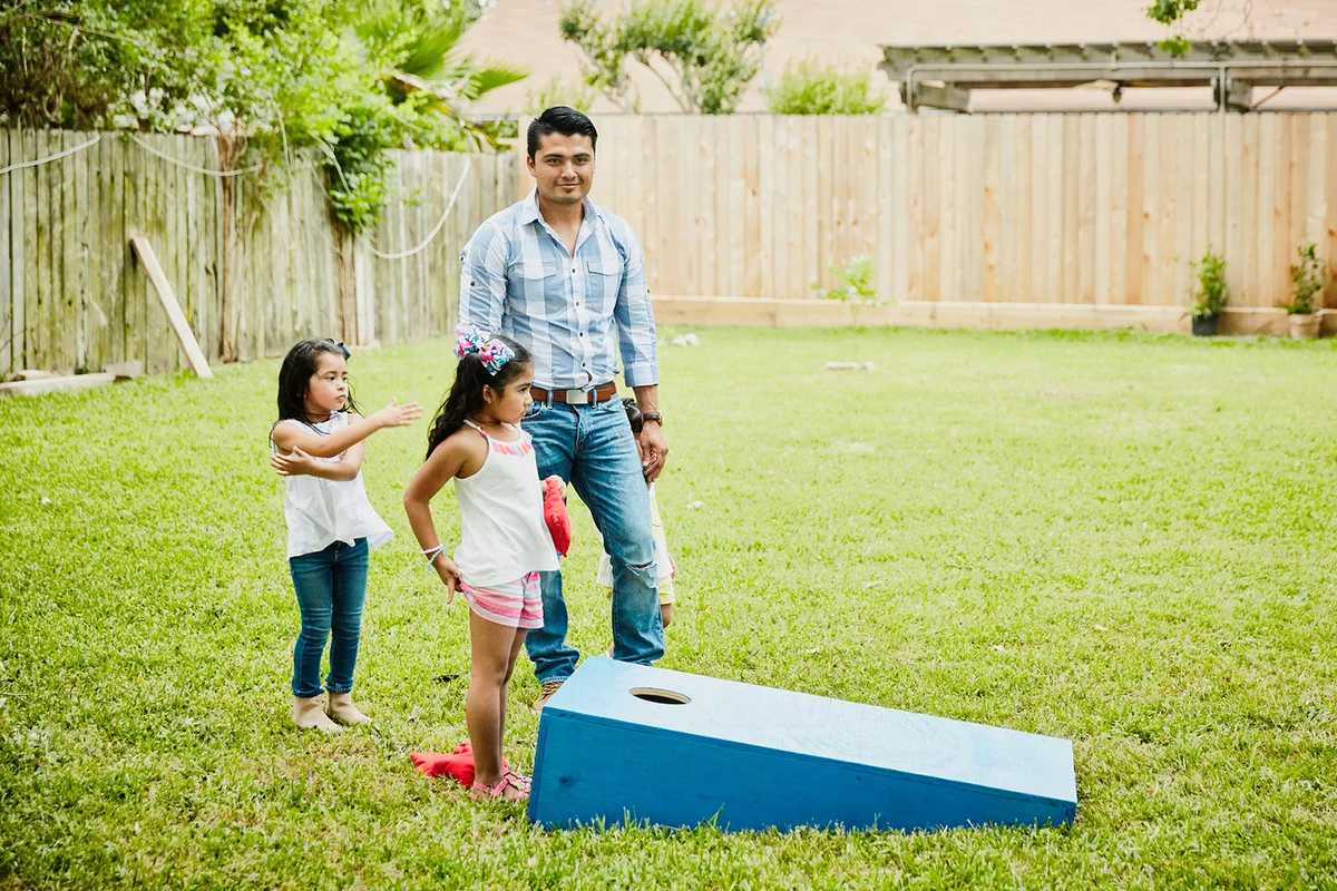 Man playing game with nieces in backyard during birthday party