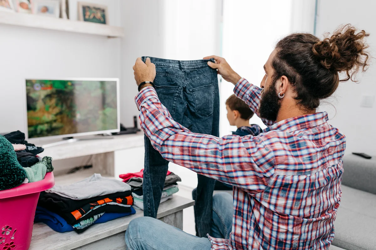 Man folding laundry in the living room
