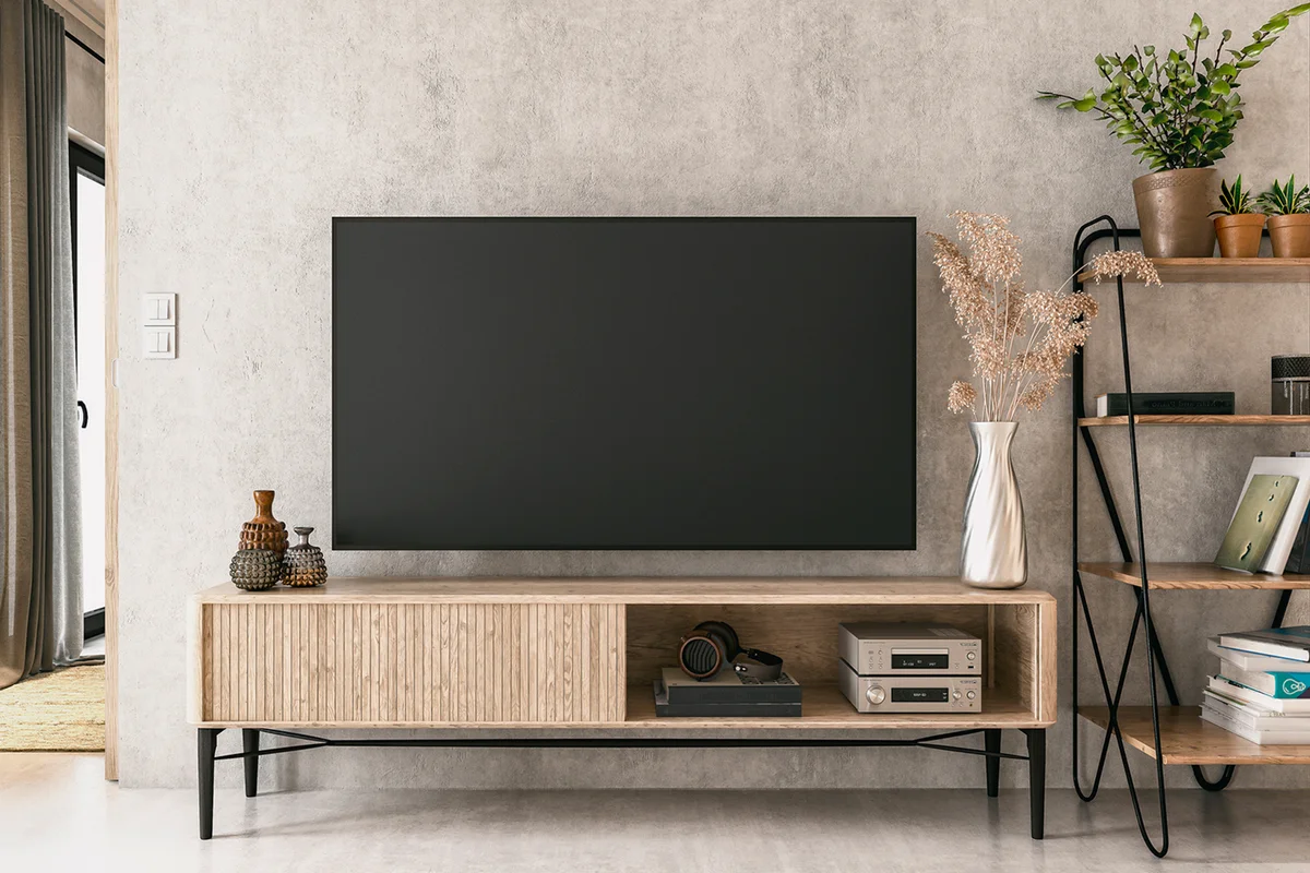 A nostalgic retro living room with a TV on a cabinet and book shelves in front of a textured ruined gray plaster wall