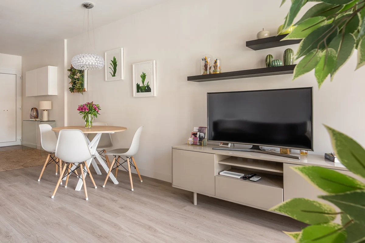 Modern interior in compact apartment with a spacious combined living room with table, chairs and TV