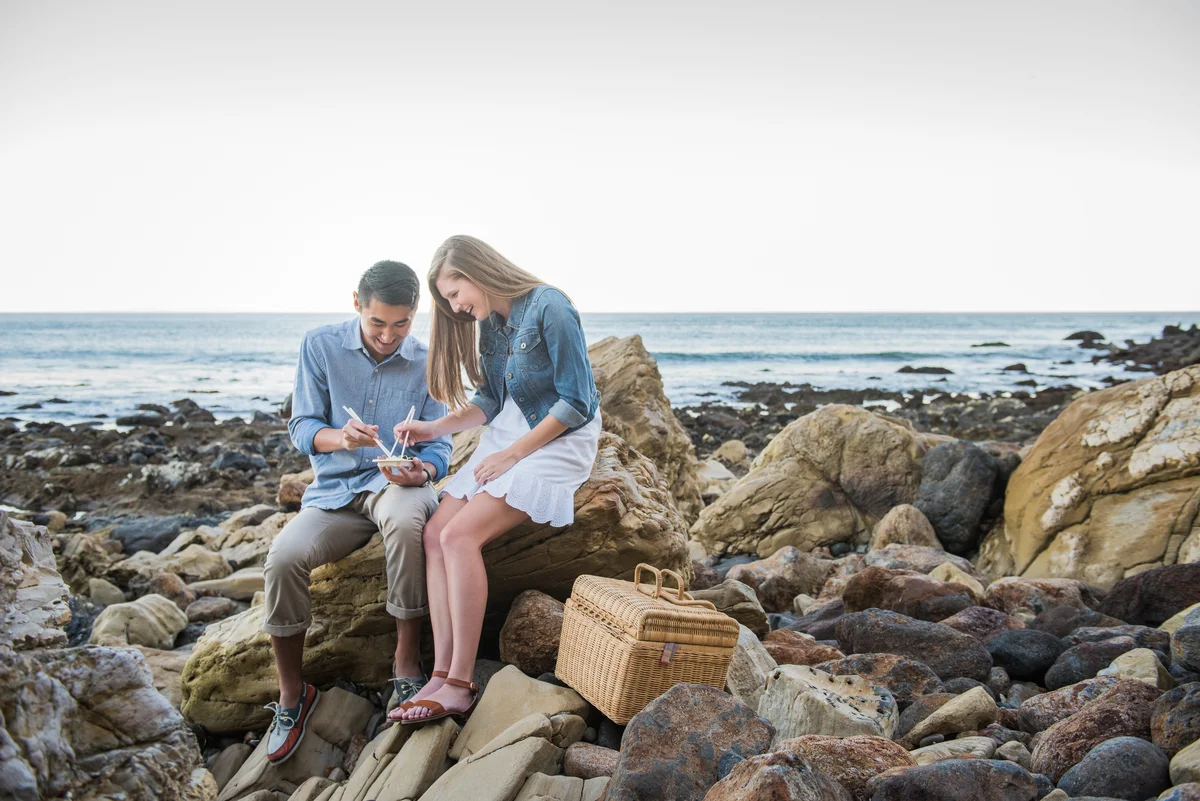 couple eating sushi at the beach