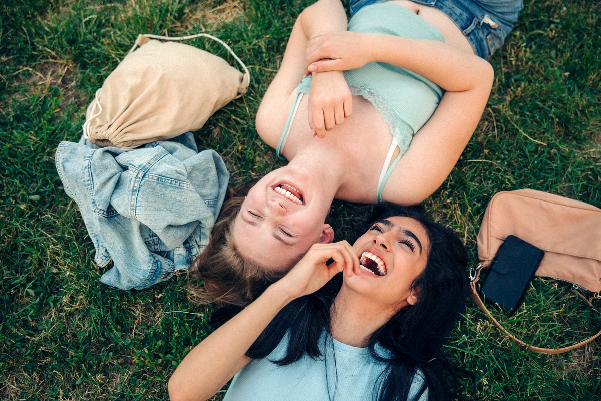 Cheerful friends lying together at park