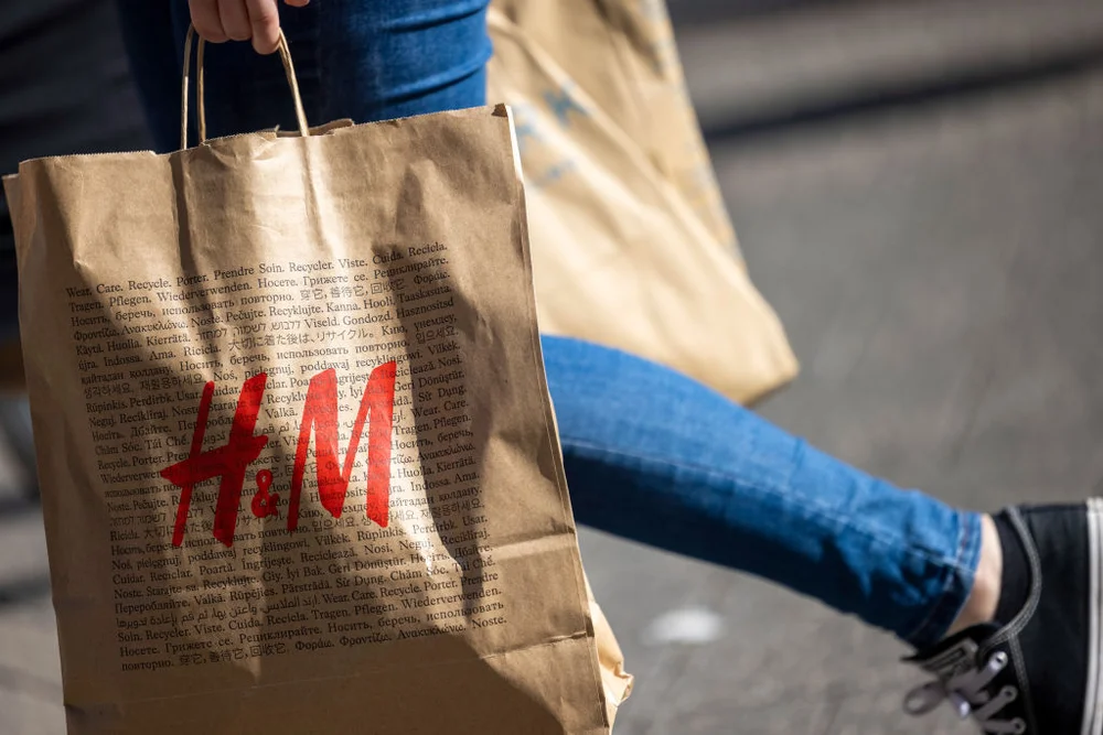 PRODUCTION - 24 June 2023, North Rhine-Westphalia, Cologne: A woman carries a paper bag with the logo of the department store chain H&M in Cologne's Schildergasse. Photo: Thomas Banneyer/dpa (Photo by Thomas Banneyer/picture alliance via Getty Images)