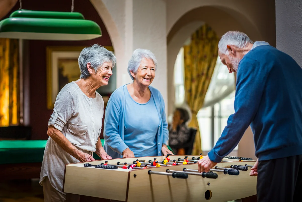 social group playing foosball at nursing home