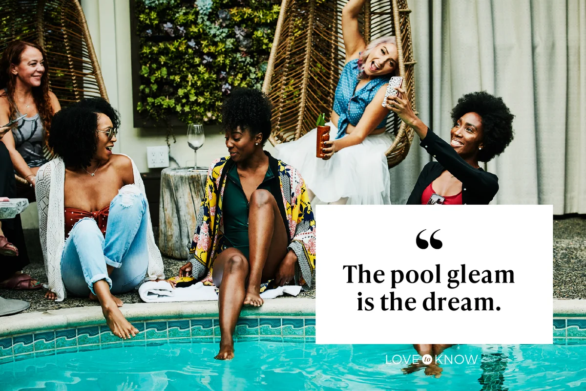 Smiling woman sitting beside pool taking selfie