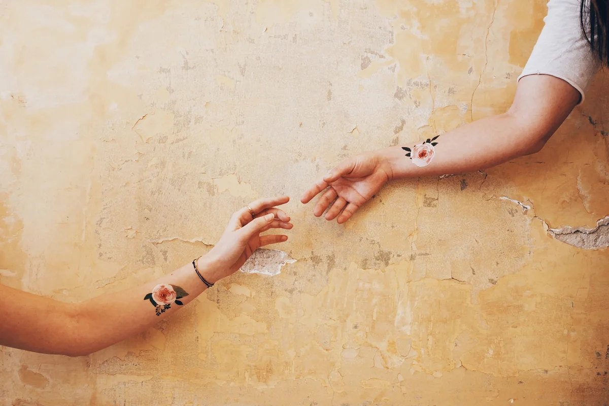 Two hands coming together in a gesture similar with the one in the Sistine Chapel
