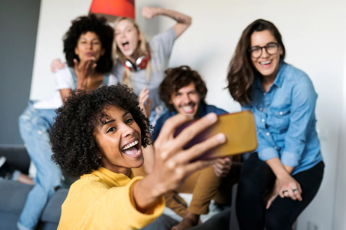 Cheerful friends taking a selfie at home