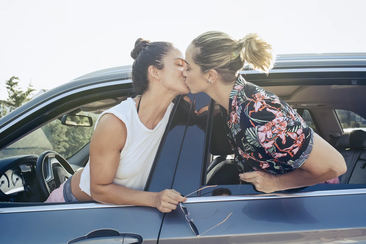 Lesbian couple kissing through car window