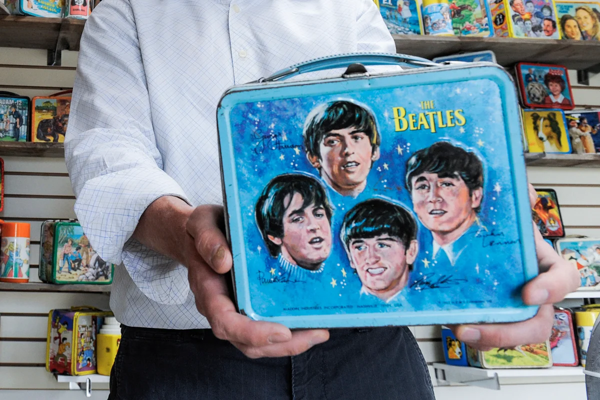 Brandon Hamilton holds a Beatles vintage metal lunch boxes