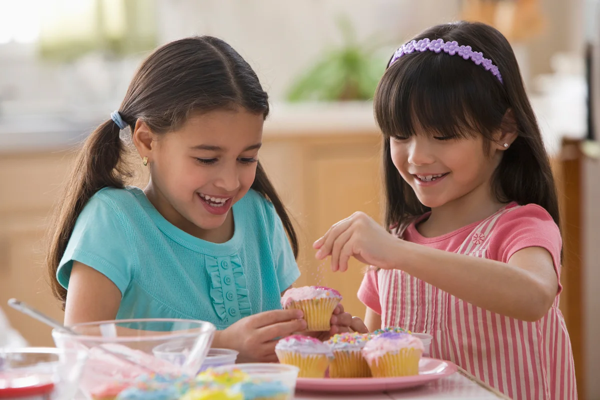 Girls decorating cupcakes together