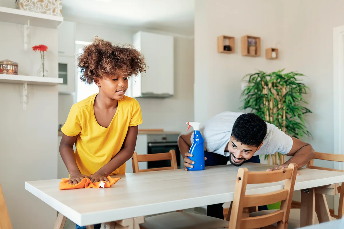 adult and child cleaning a table