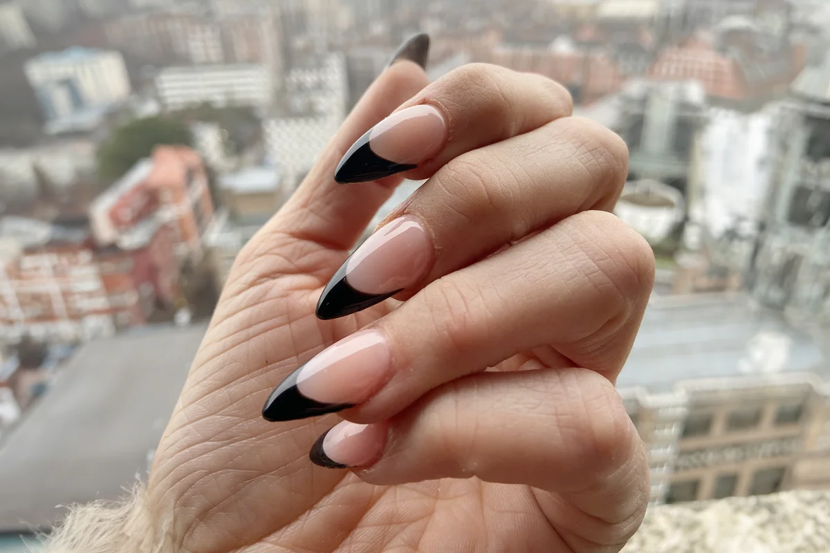 Black tip French manicure with claw points trendy nail design in acrylic applied nail art