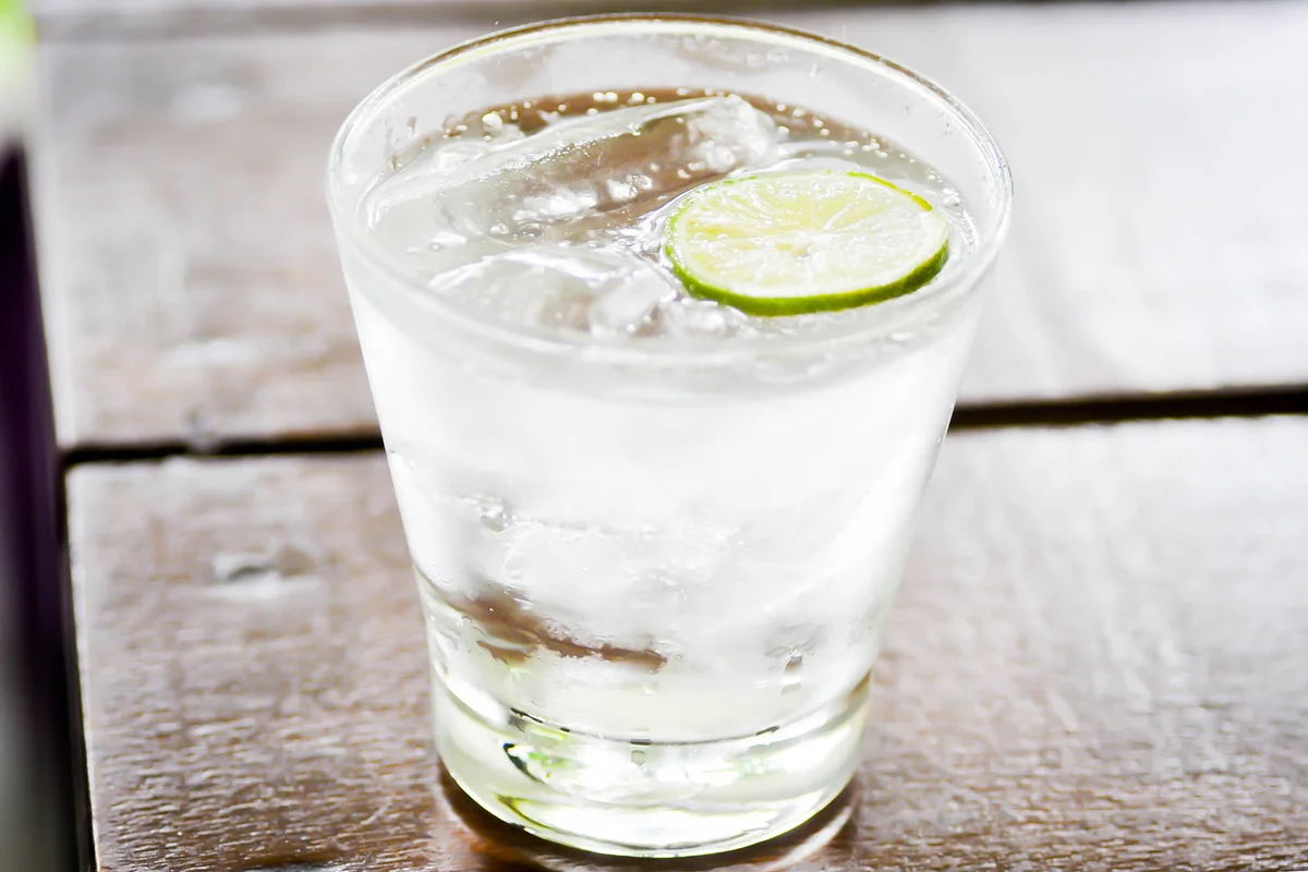 a glass of soda and lime slice