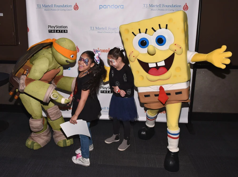 Michelangelo the Teenaged Mutant Ninja Turtle (L) and SpongeBob SquarePants (R) meet guests at T.J. Martell Foundation's 17th Annual New York Family Day at PlayStation Theater on April 8, 2018 in New York City