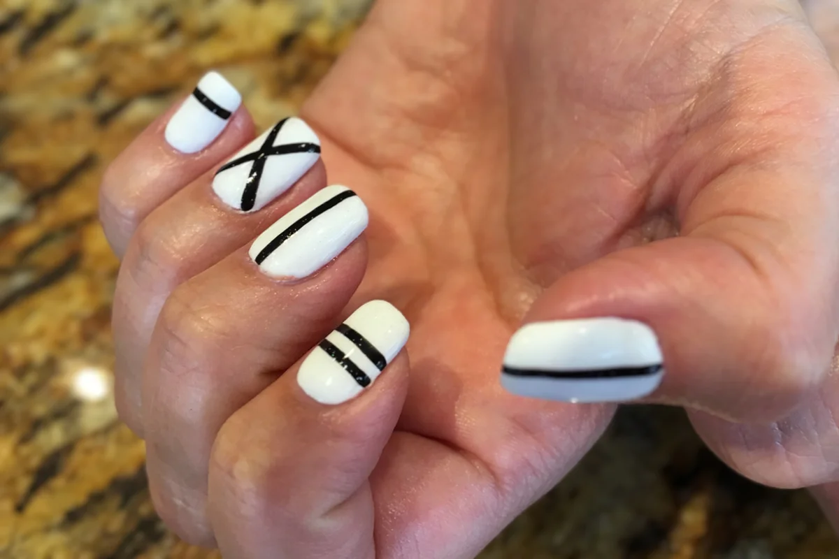 White nail varnish with black stripes