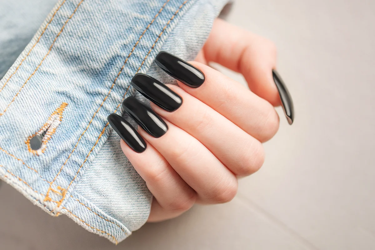 Hand of a young girl with black manicure on nails