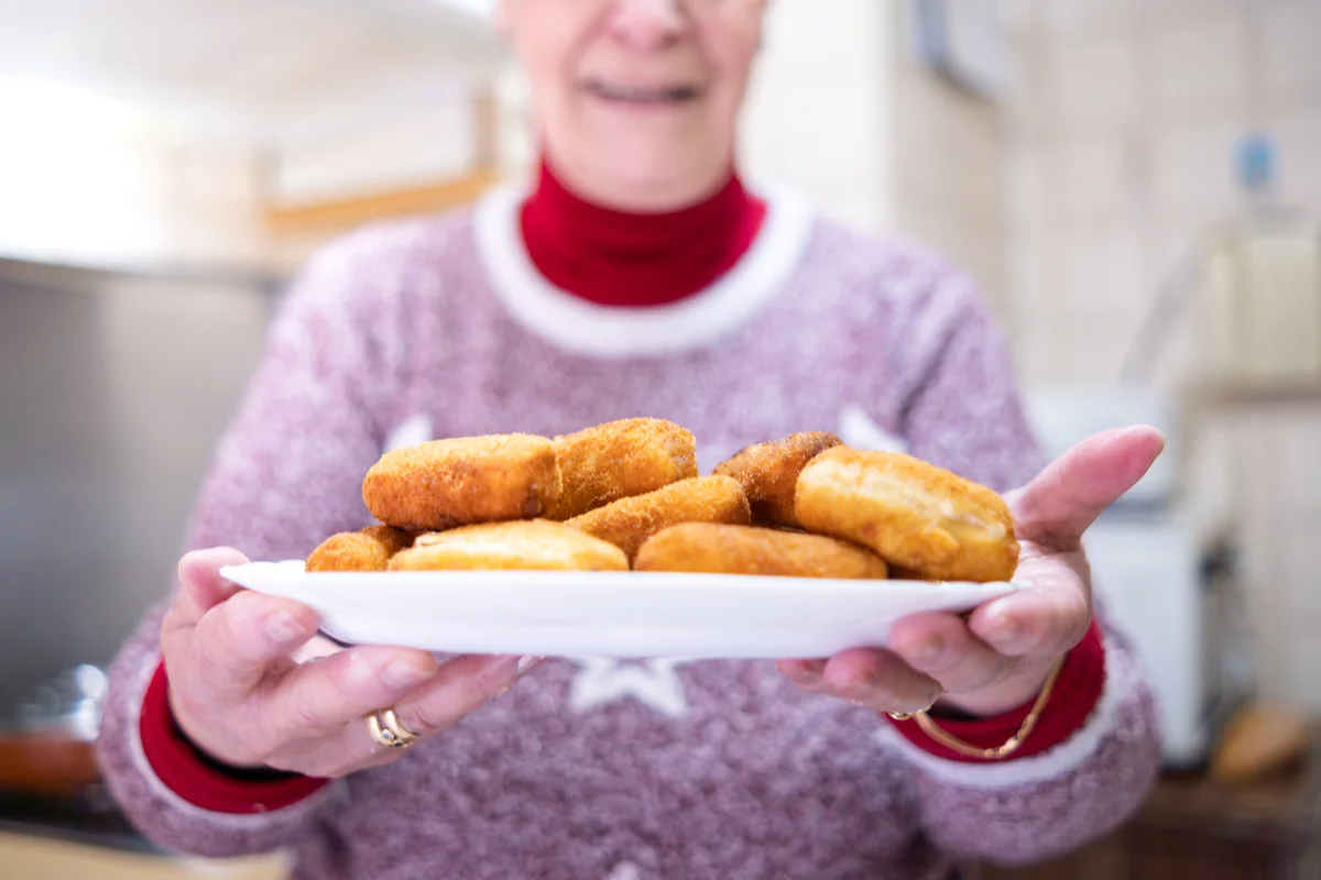 woman holding a tray of fried food