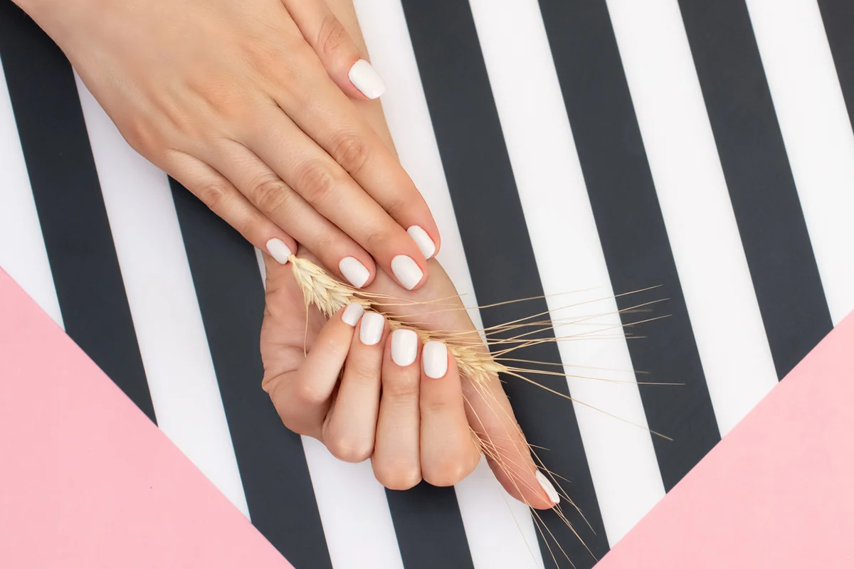 Beautiful young woman's hands on pink and black background