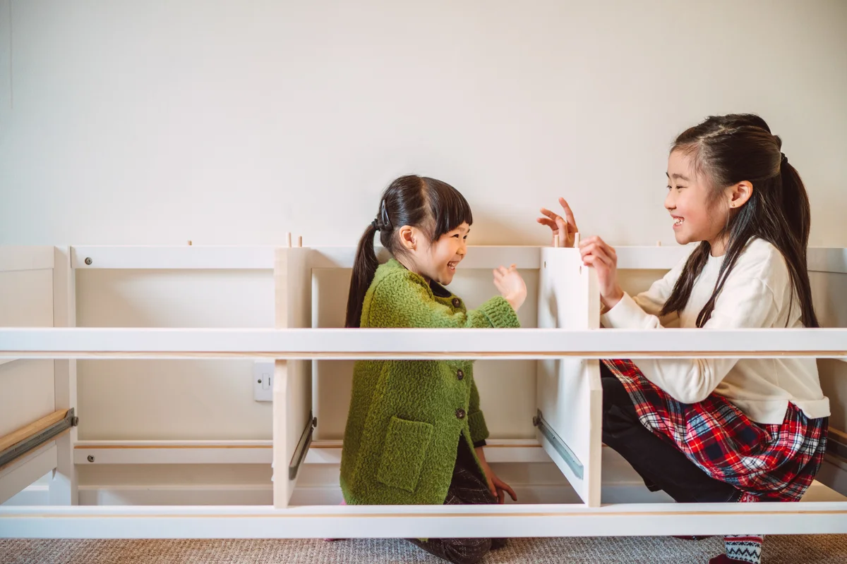 Two little girls playing in Ikea furniture
