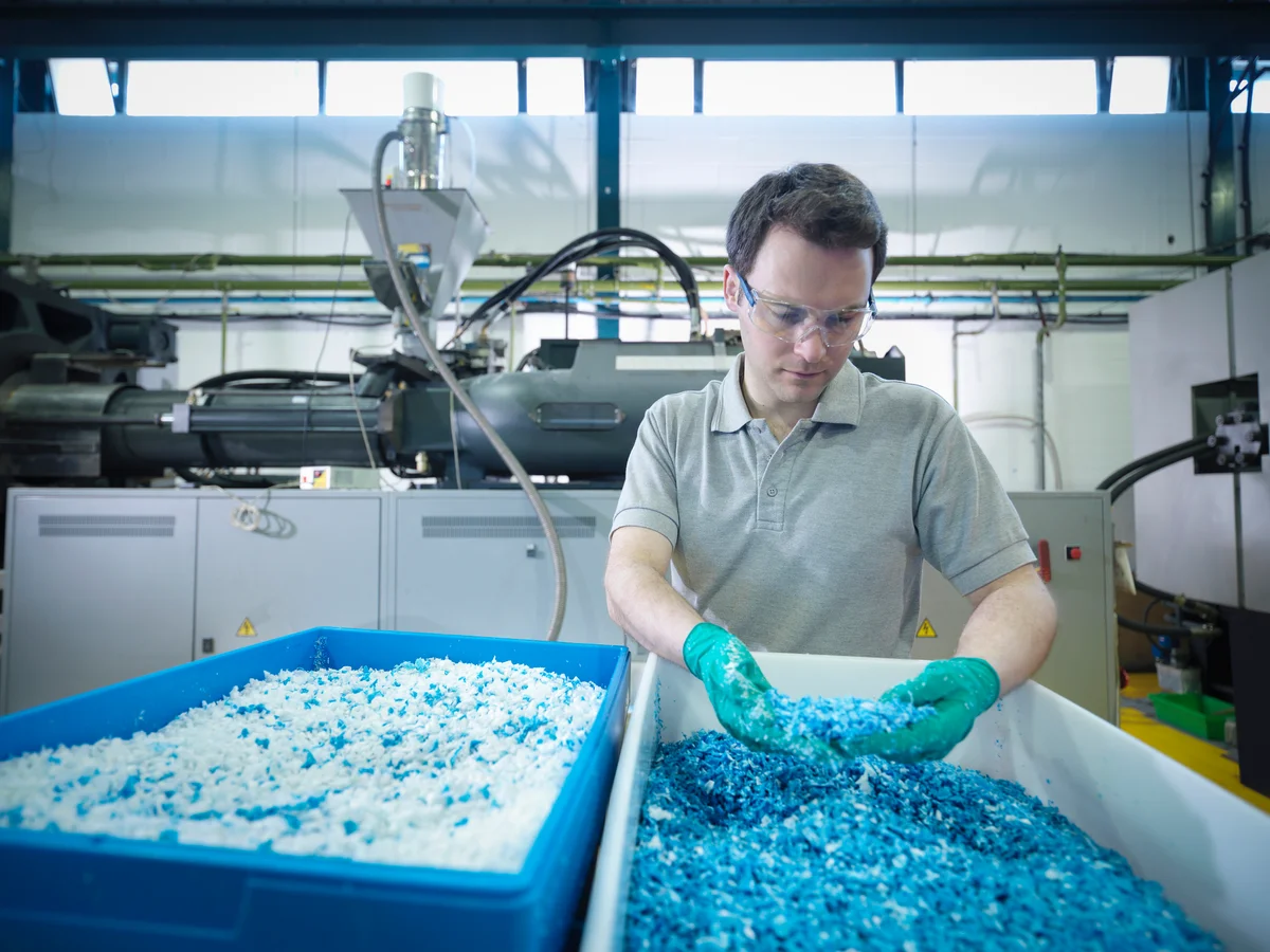 Man sorting through recycled plastics