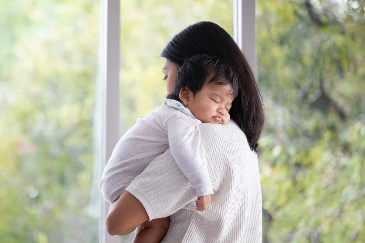Mother embracing her baby girl while sleeping