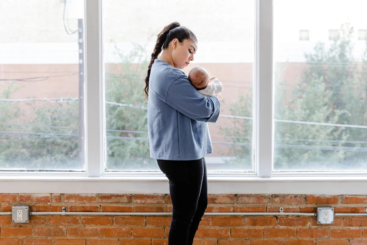 young adult mom walks with her baby girl