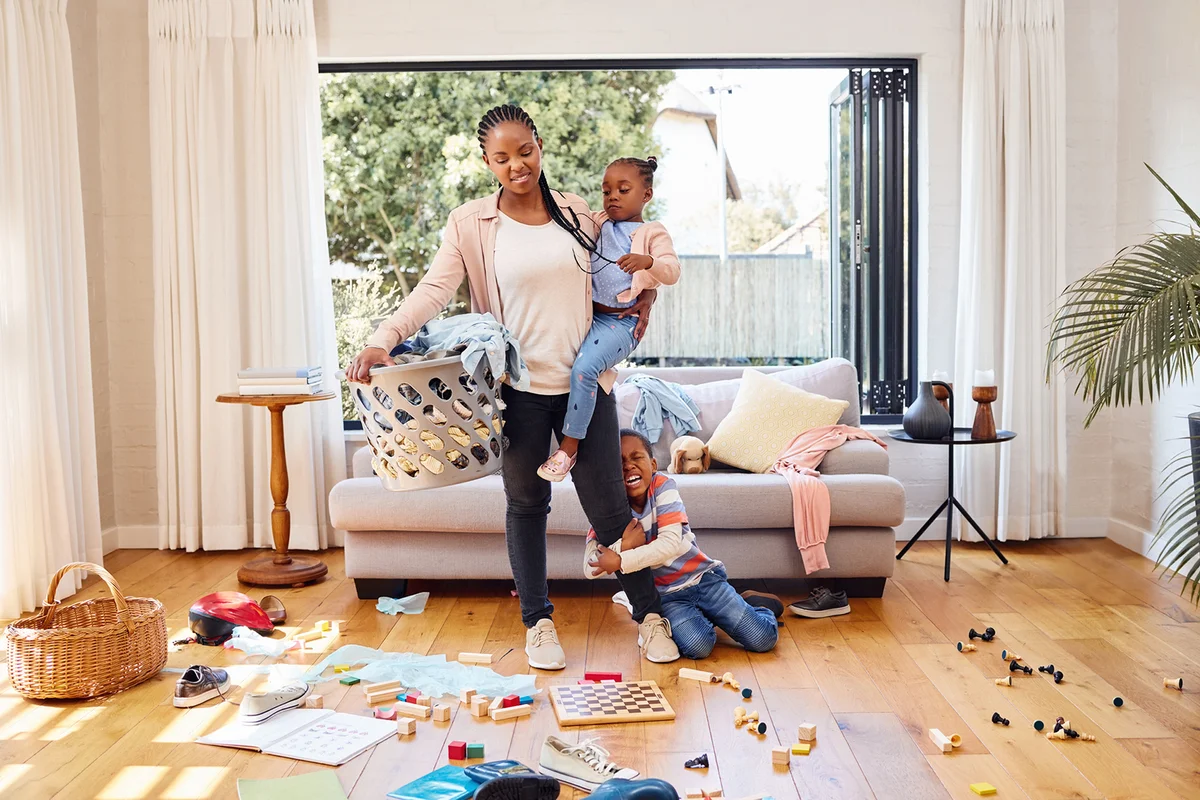 Shot of a little boy throwing a tantrum while holding his mother's leg at home