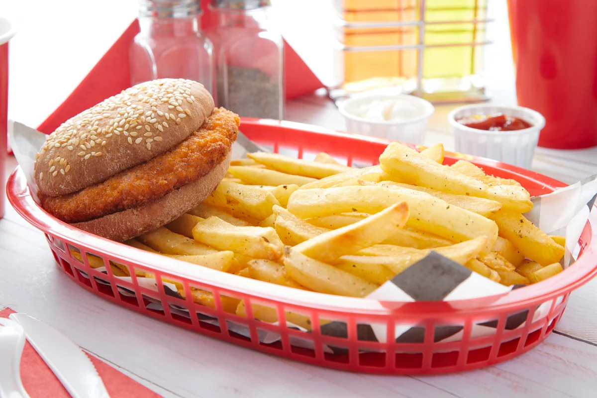Spicy chicken burger in a basket with french fries