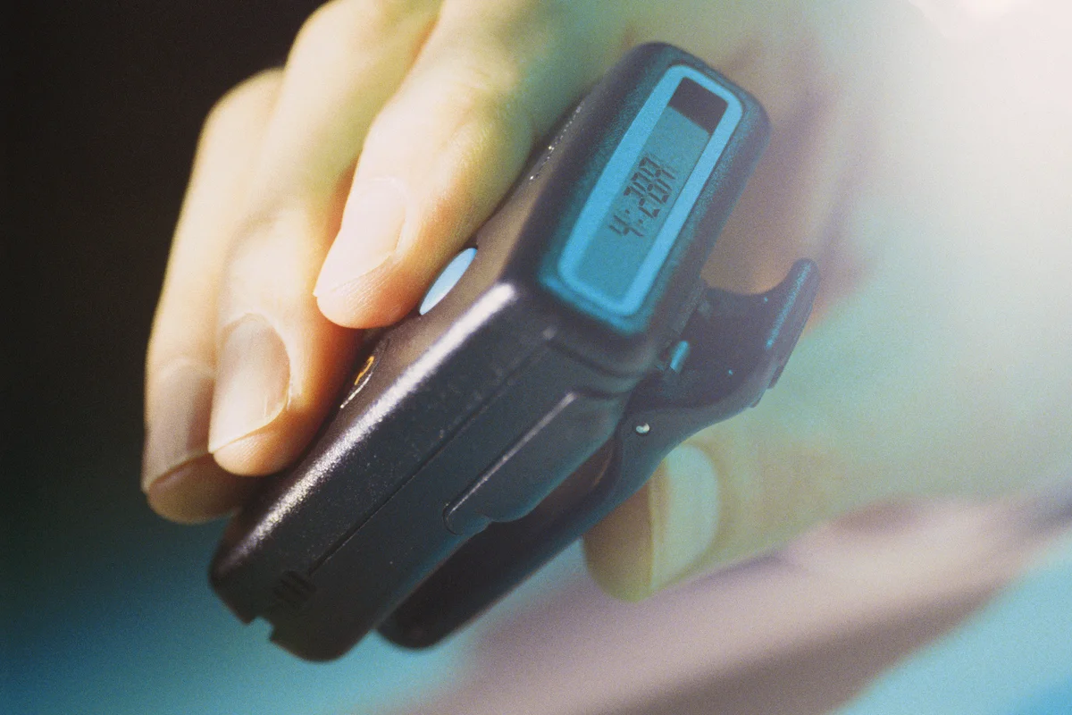 90s photo of hand holding a pager