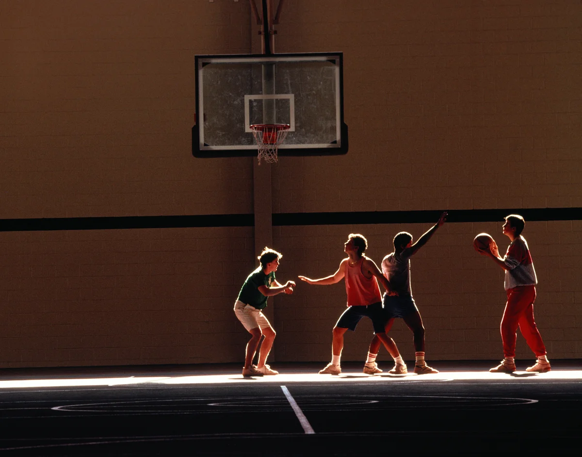 Group of boys in 90s playing basketball in gym