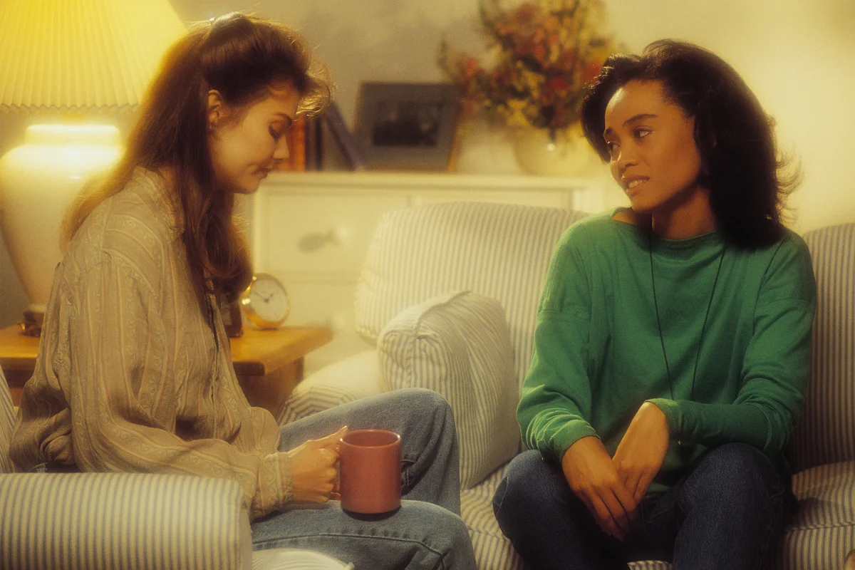 Two women talking seriously in the 90s