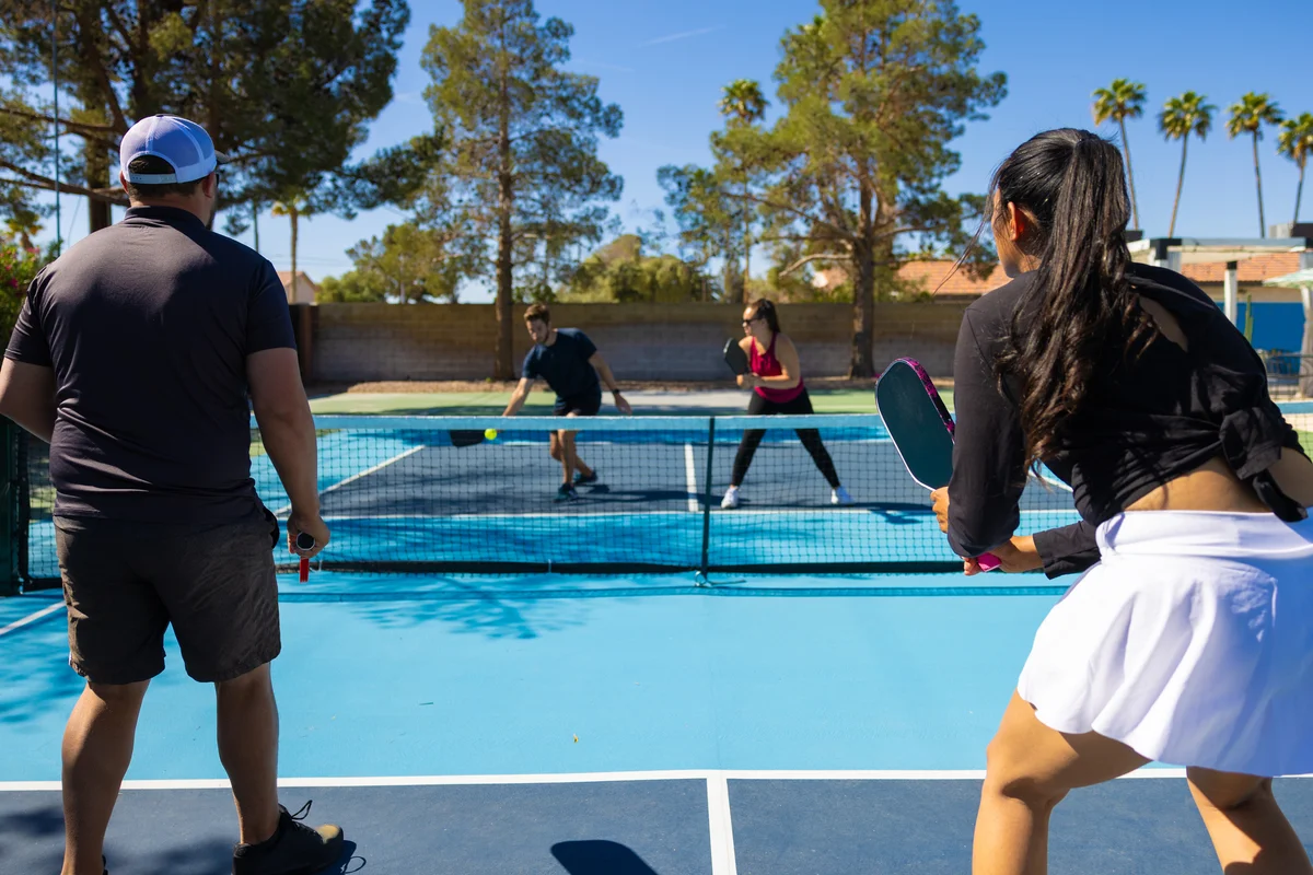 A group of four playing pickleball on a sunny day