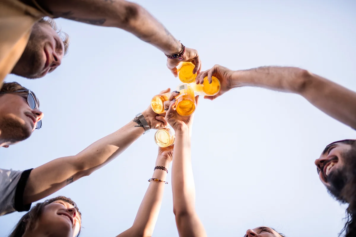 Group of young people cheersing beers