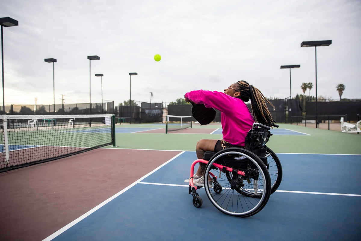 A woman in a wheelchair playing pickleball