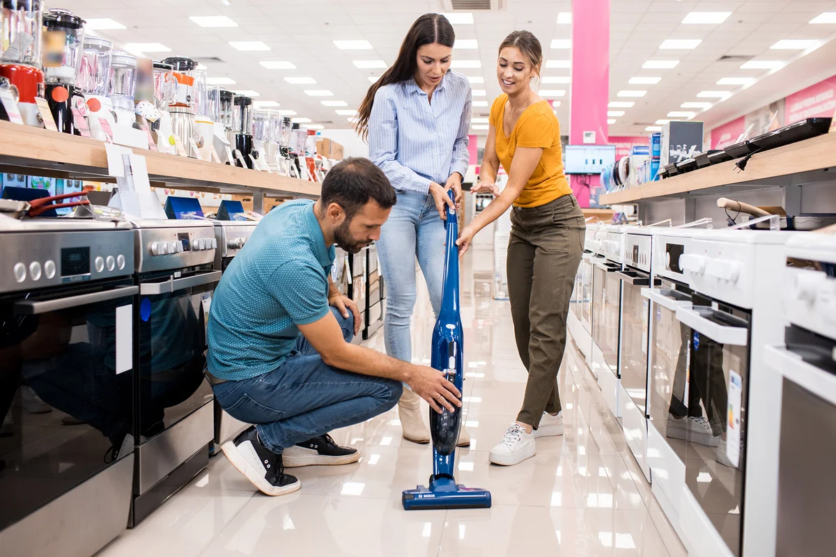 Young couple gets assistance with the vacuum cleaner
