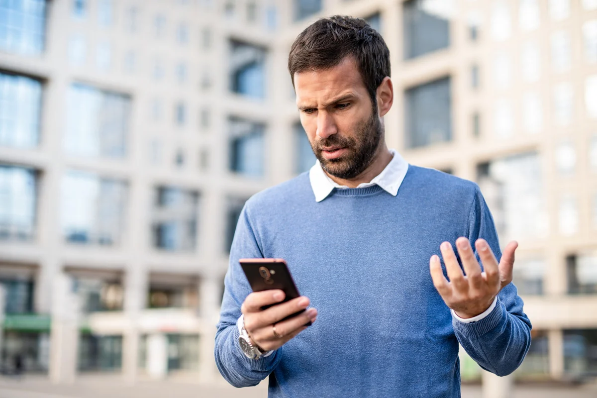 Frustrated mid adult man using phone