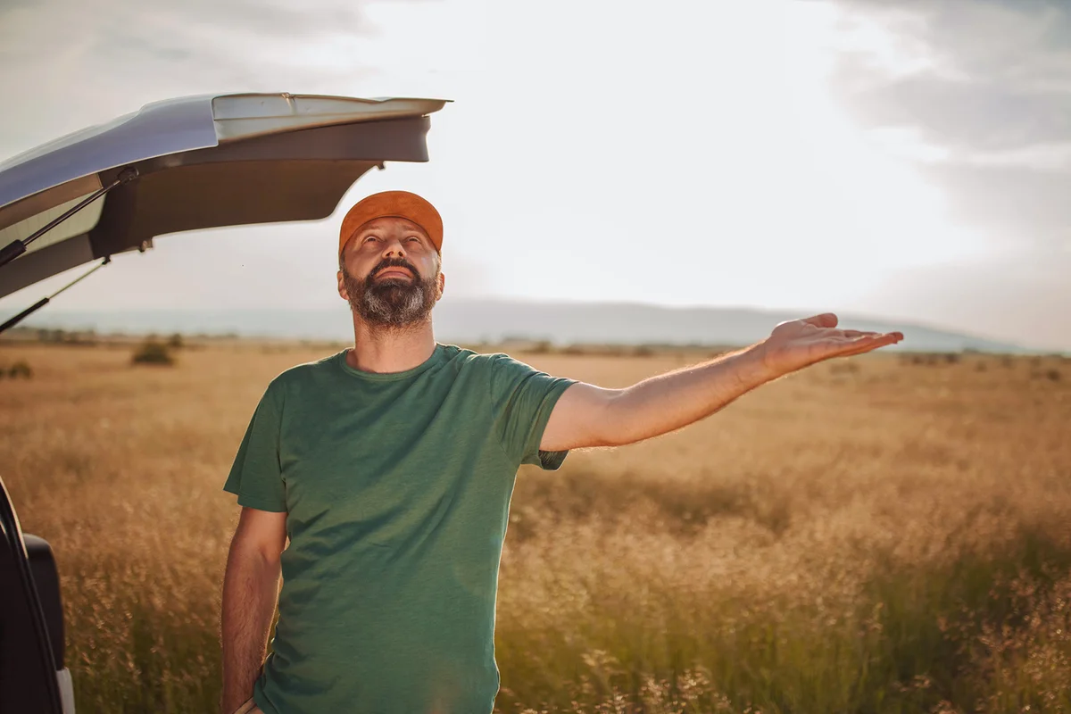 farmer near the car on the field