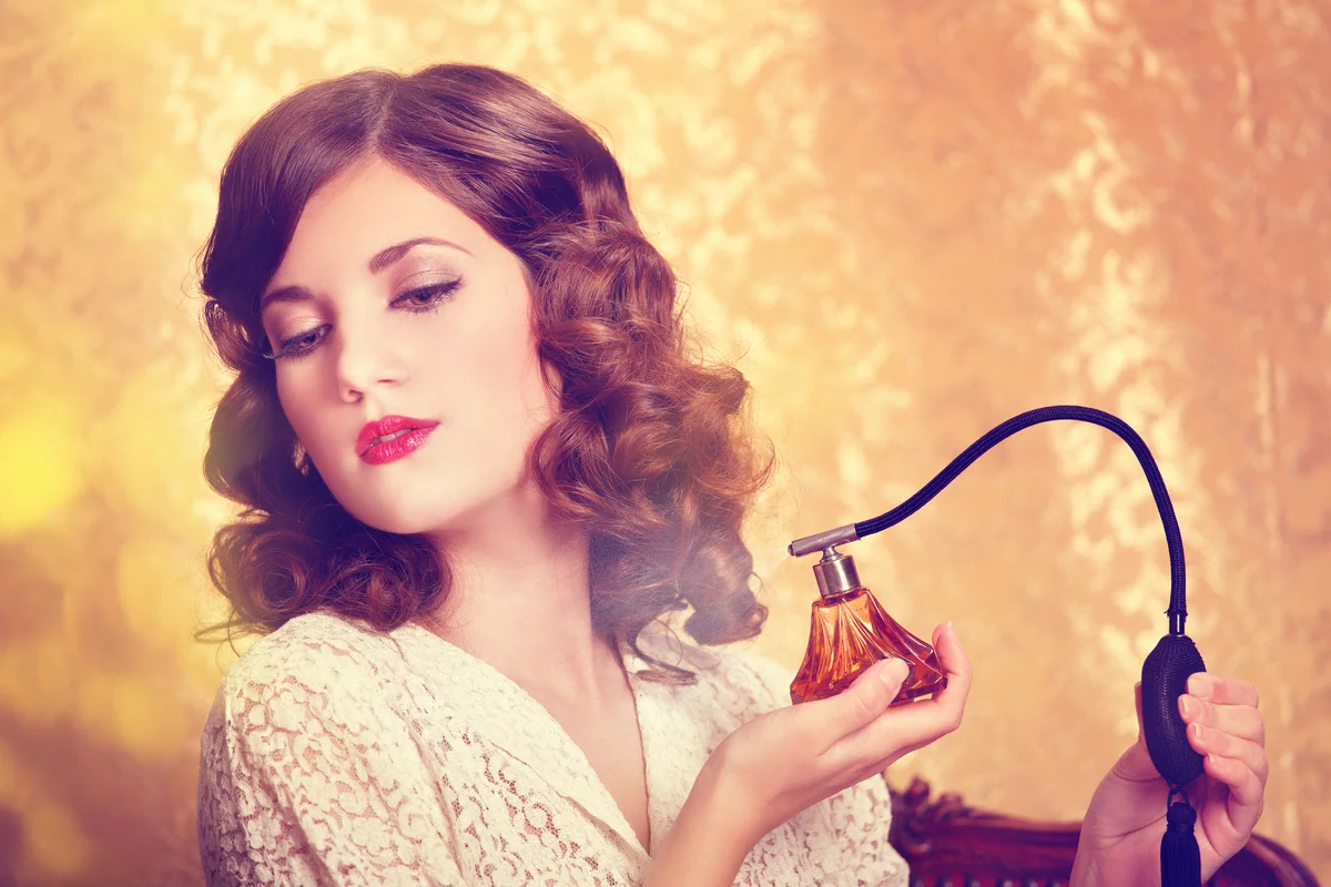 Retro girl applying perfume