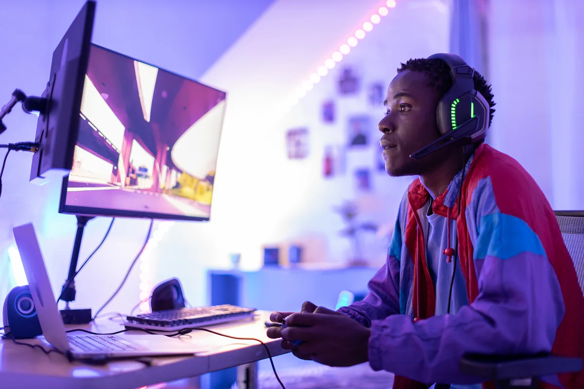 Young male gamer playing at night