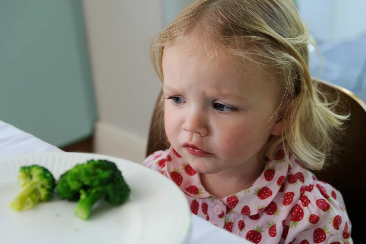 Little girl not wanting to eat broccoli