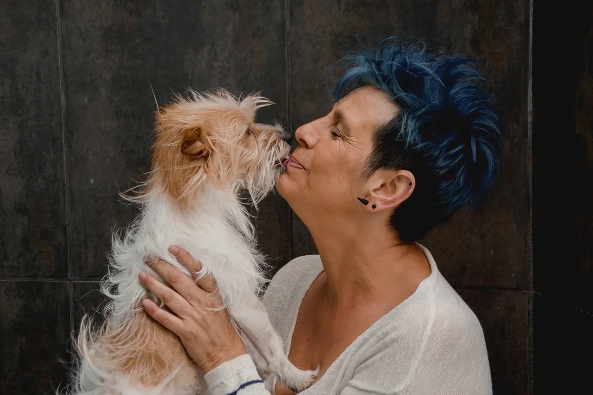 Woman kissing purebred terrier