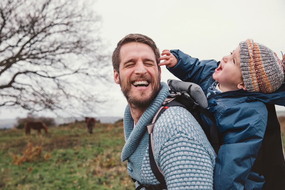 A father laughs share a funny moment whilst walking in the countryside