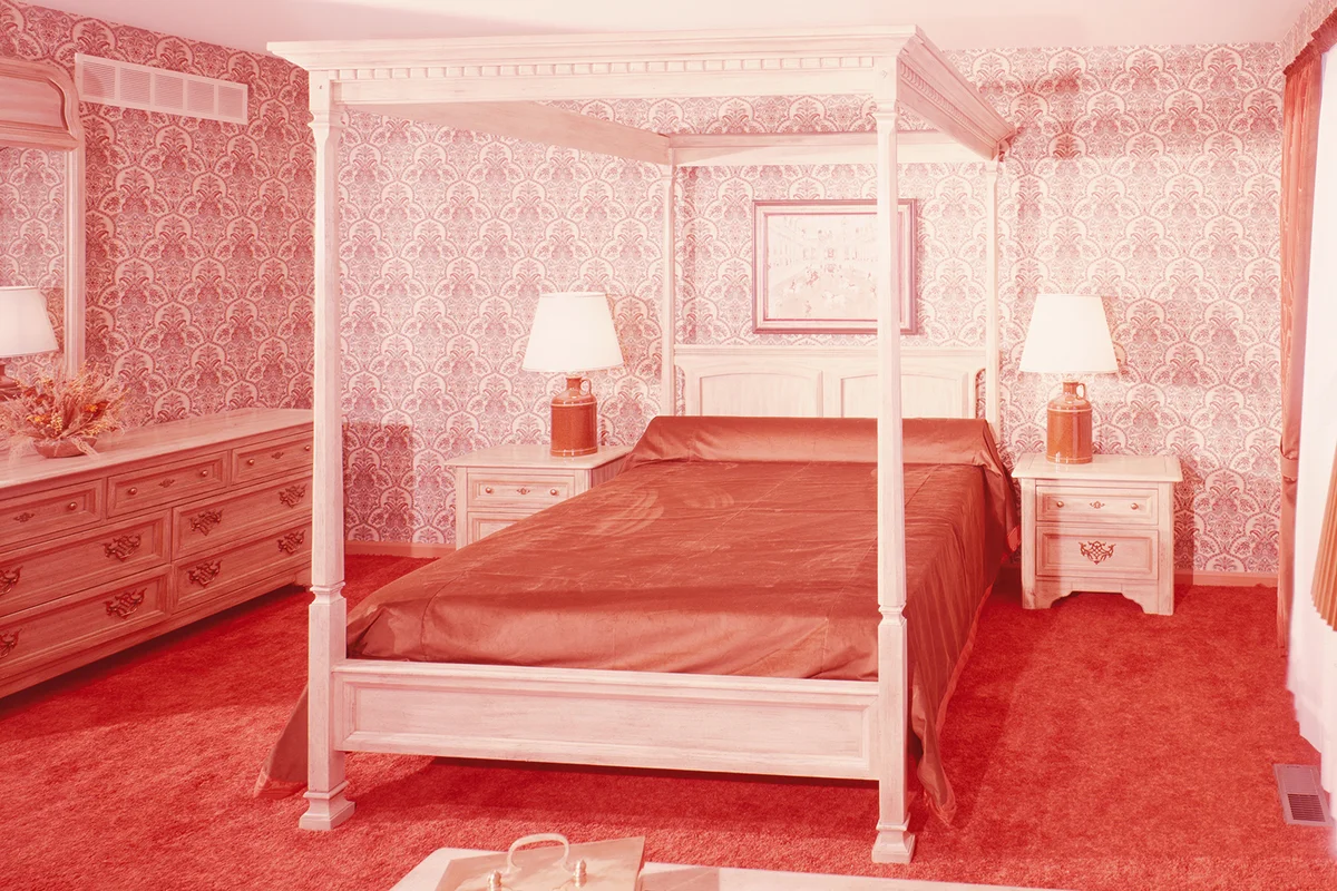 Four poster bed in bedroom with wall to wall shag pile carpeting