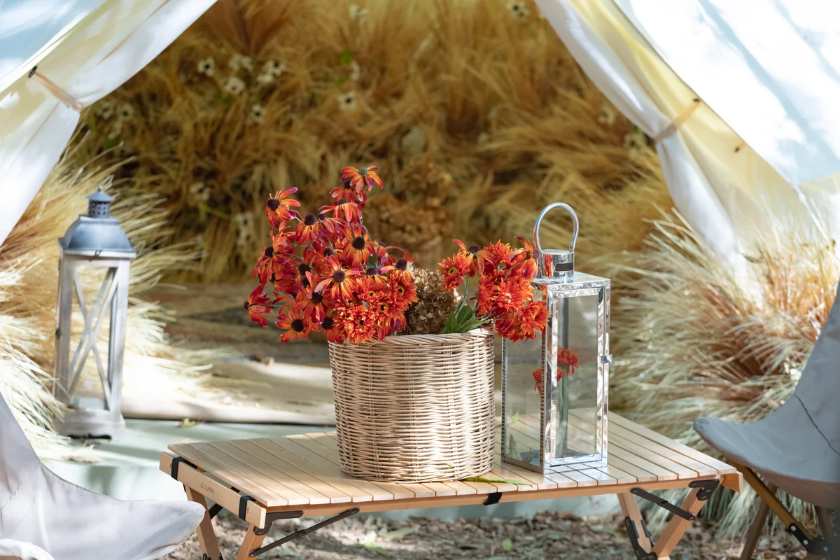Tent in the park decor in boho style, basket with flowers for centerpiece