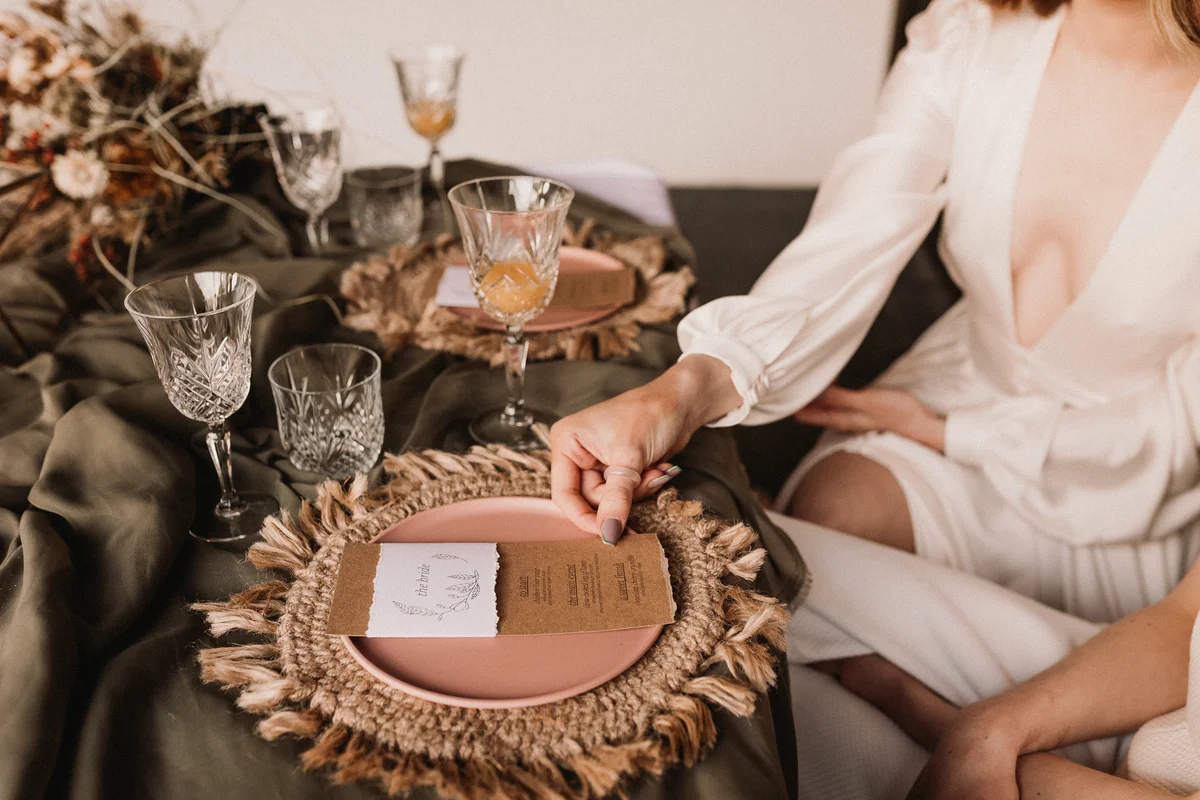 Macrame charger on wedding table while bride holds paper