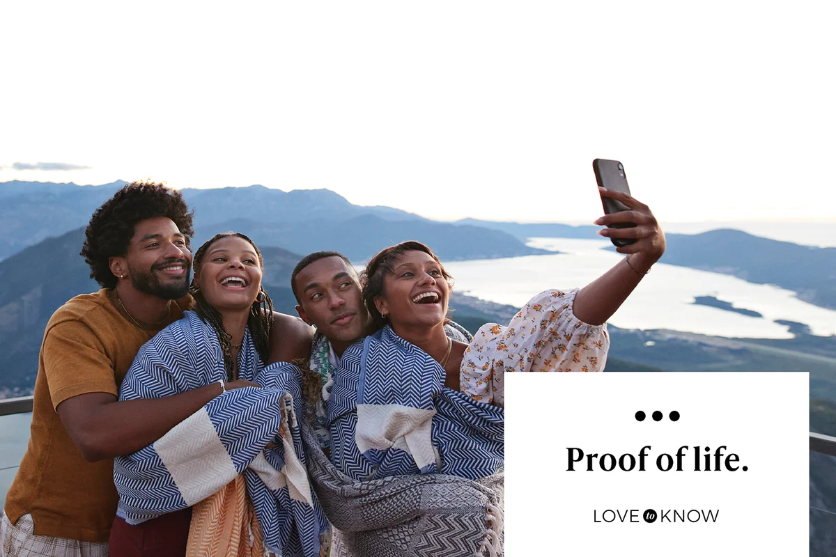 Woman taking selfie with friends on smart phone